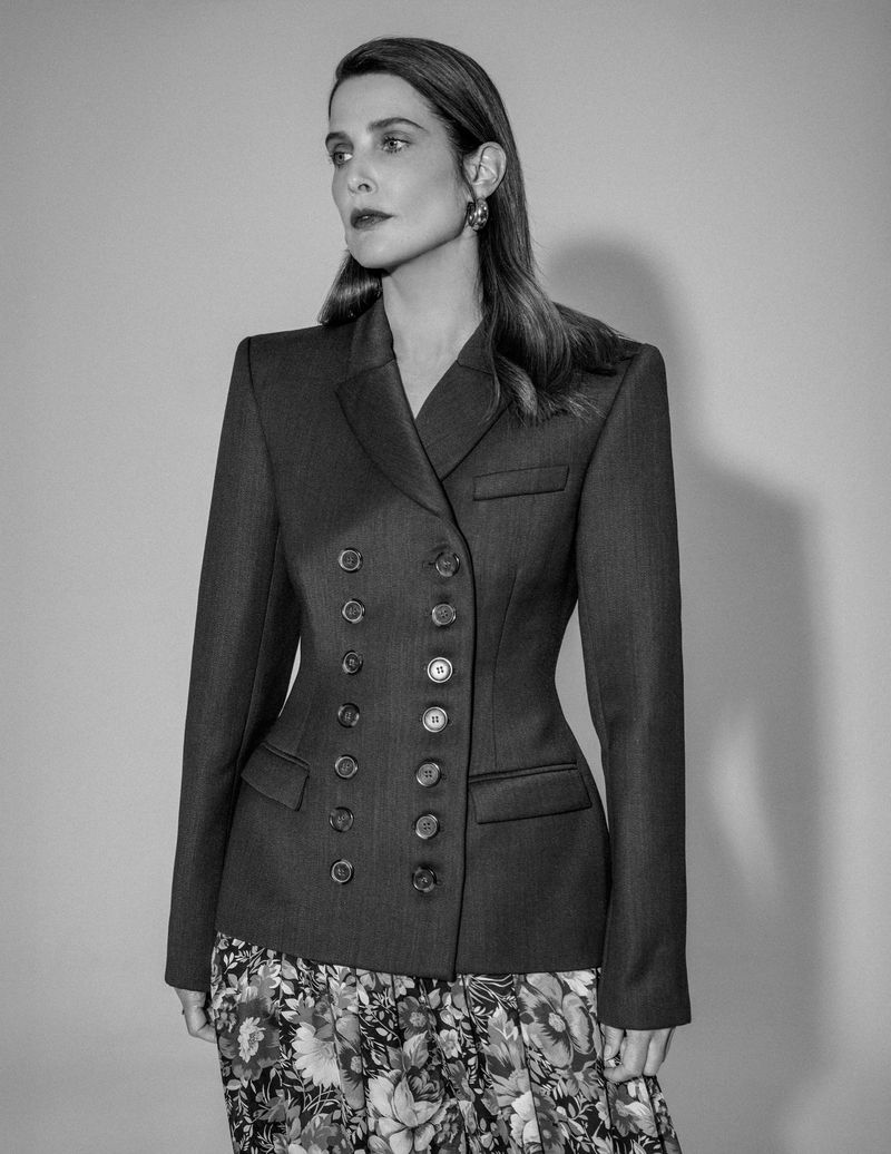 Cobie Smulders wearing a double-breasted blazer and floral skirt in a black and white portrait for Numero Netherlands.