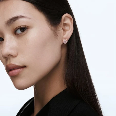 Close-up shot of a young Asian woman with flower earrings. The focus is on the woman's face and the jewelry detail against a clean backdrop.