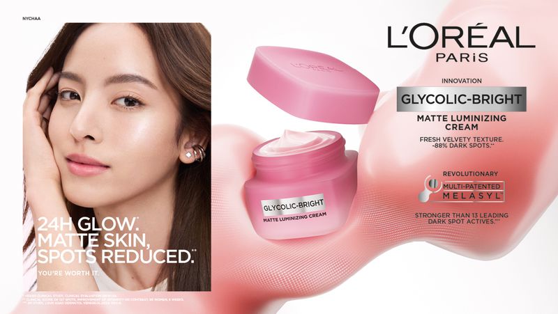 Cosmetics ad featuring an Asian woman promoting L'Oréal Glycolic-Bright Matte Luminizing Cream with bright, even-toned skin in a studio.