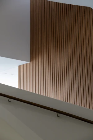 Interior architectural view of vertical wood batten wall paneling and a white ceiling with clean modern lines.