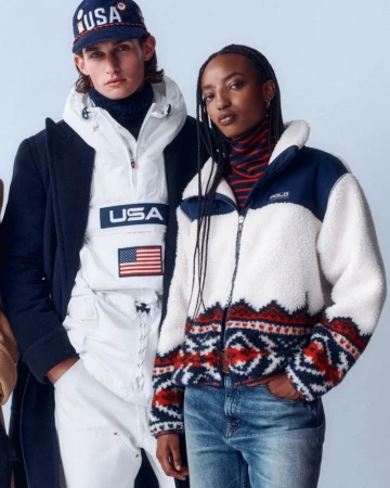 Two fashion models pose indoors in bright light wearing preppy winter clothing: jacket, hoodie, cap, turtleneck, coat and jeans.