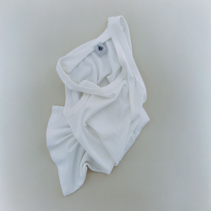 White baby bodysuit and briefs set on neutral background, featuring soft cotton fabric and classic design for infants.