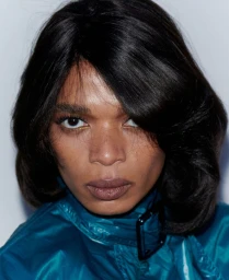 Close-up portrait of model Raven Wallace wearing a teal jacket and dark hair for M Le magazine du Monde