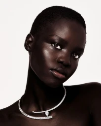 Close-up portrait of a model wearing a sparkling diamond choker necklace against a clean white background.
