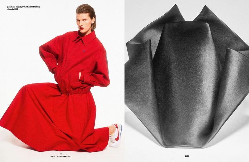 Editorial fashion shot of a woman in a red jacket and long skirt kneeling, with a dark folded cloth sculpture to the right.