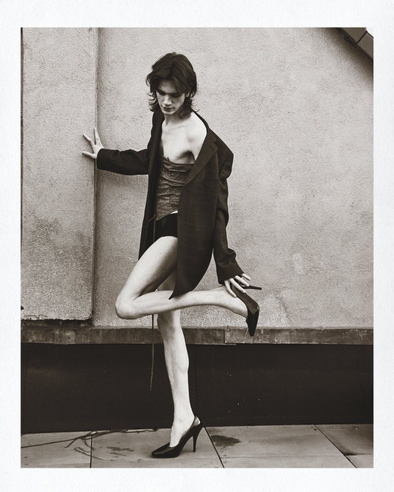 Model in oversized black blazer and heels posing against a textured wall for Numero Netherlands Blisters