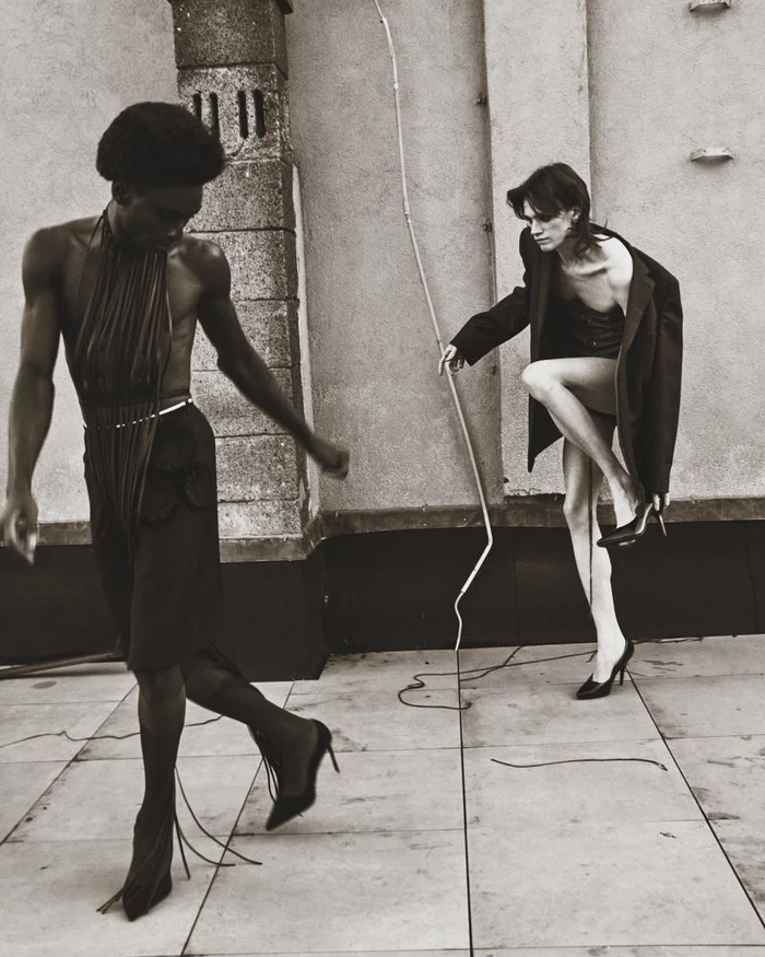 Two models posing on a rooftop wearing heels and dark clothing for Numero Netherlands editorial photography by Sieme Hermans.