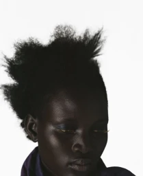 Portrait of a black woman wearing a purple top against a white background from Lights Off for The Correct Distance