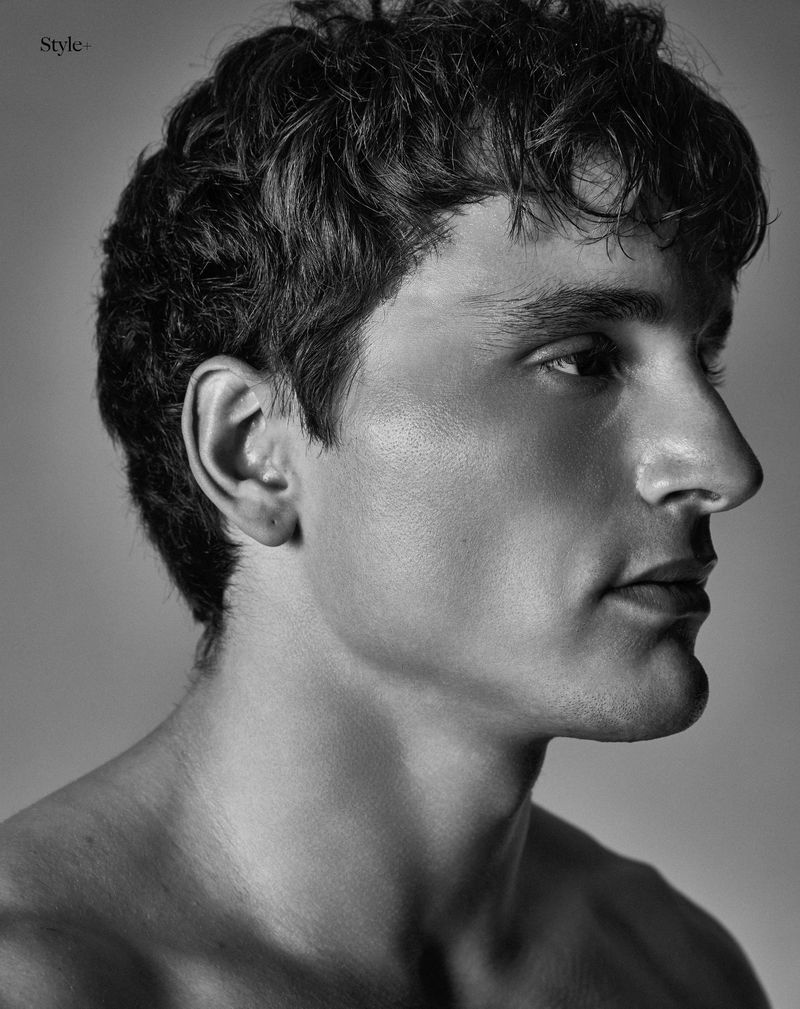 Profile portrait of a man with short dark hair against a neutral studio background for The Perfect Man Magazine.