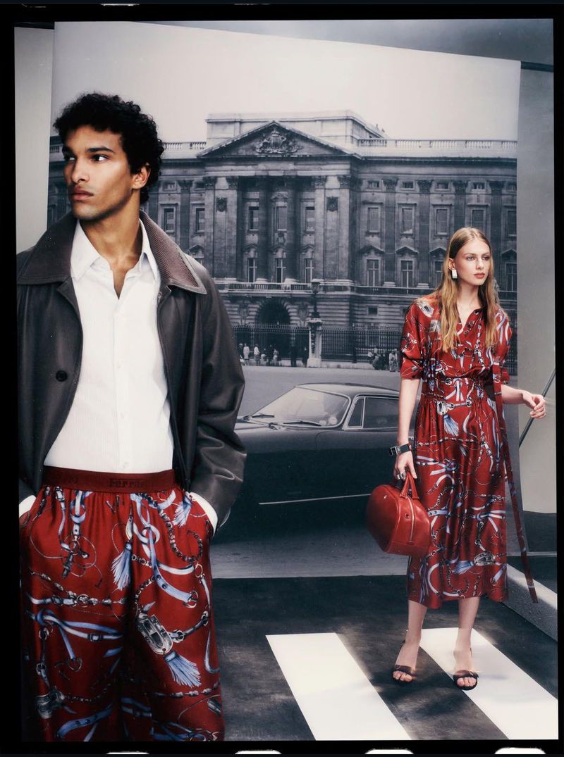 Fashion editorial shot with a male model in patterned pants and jacket, and a female model in a printed dress in a studio setting.