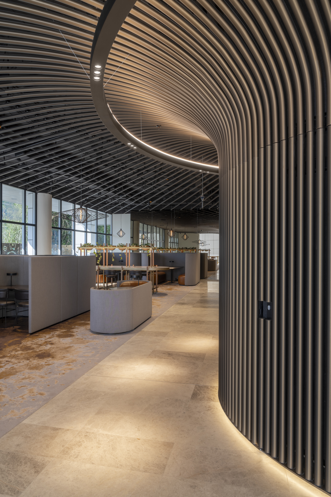 Interior view of an office space featuring neutral tones, modern furniture, and architectural lighting design, creating a contemporary work environment.