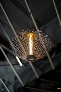 A modern geometric wireframe pendant light hanging in an industrial interior space by Keece Electrical.
