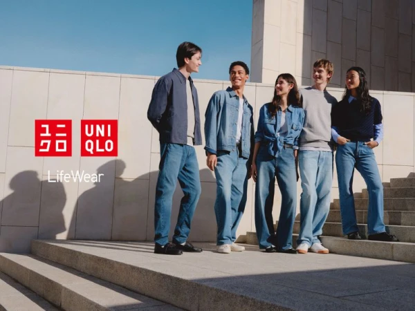 A group of five young adults pose on concrete steps against a neutral background, showcasing diverse styles of denim clothing and Uniqlo branding.