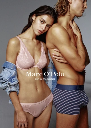 Promotional shot featuring a woman in lingerie and a man in underwear standing close against a solid background, showcasing Marc O'Polo brand.