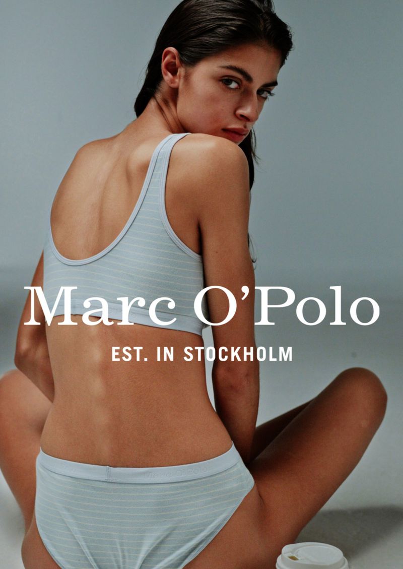 A woman poses in a light blue striped two-piece lingerie set against a gray backdrop, featuring the 'Marc O'Polo' logo.