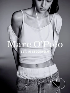 Monochrome fashion advertising image featuring a model wearing a camisole and denim jeans with visible headphones