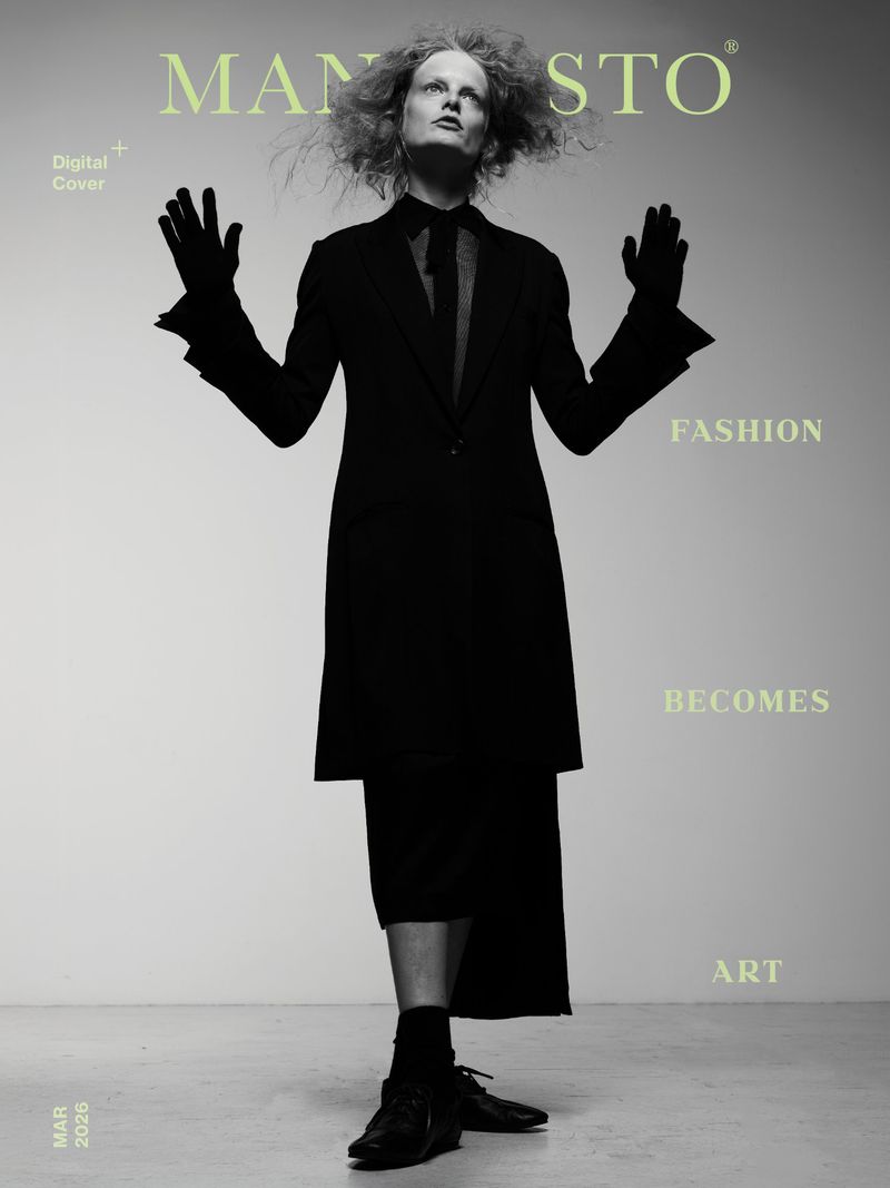 Magazine cover featuring a model in a black suit with hands raised, title 'MANIFESTO', fashion becomes art.