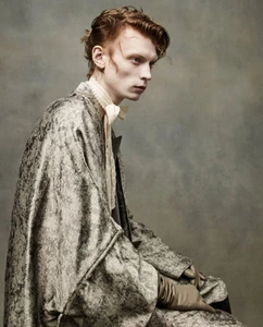 Model Owen Ruppersburg wearing a textured grey coat and lace cravat for ICON America SS26 by Sølve Sundsbø