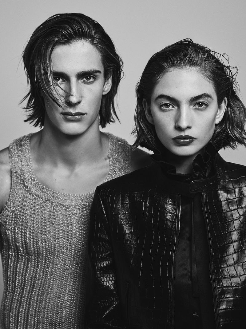 Black and white portrait of a stylish couple. The male model wears a knit top, while the female model wears a crocodile pattern leather jacket.