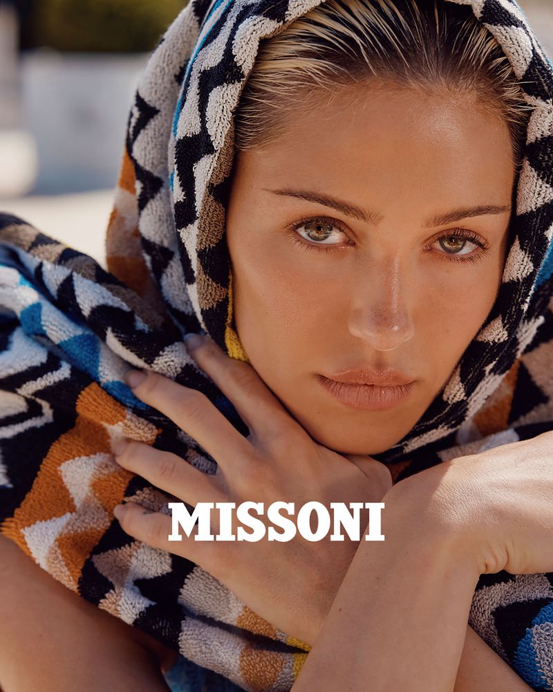 Close-up of a female fashion model with a patterned headscarf; beauty shot with soft lighting and the brand name 'Missoni' visible.