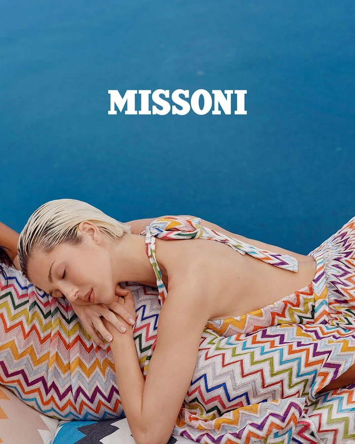 Model Delilah Belle wearing a colorful zigzag print top against a bright blue background for Missoni Spring Summer 2025.