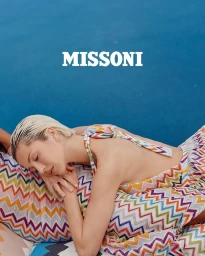 Model Delilah Belle wearing a colorful zigzag print top against a bright blue background for Missoni Spring Summer 2025.