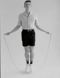 Model Joe Baker jumping rope against a plain white background for U Repubblica, photographed by Bruno Staub.
