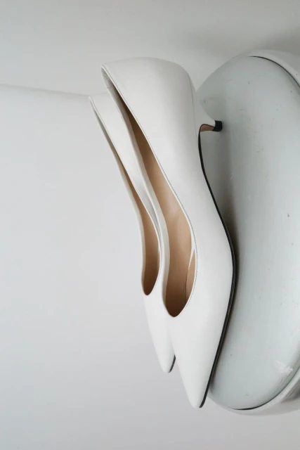 Elegant white heeled shoes on a white surface, perfect for fashion and beauty-related content. Minimalist aesthetic.