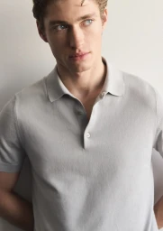 Close-up portrait of a male model wearing a light grey polo shirt against a plain light background for Mango Man.