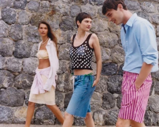 Three models walking outdoors in front of a rustic stone wall for J. Crew Summer 25 campaign