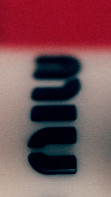 Close-up of blurred Wilson brand logo on white and red background, showcasing brand identity with a soft, abstract focus.