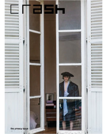 Fashion magazine cover: a woman in a jacket and hat stands framed by an open window with white shutters, promoting the Privacy Issue.