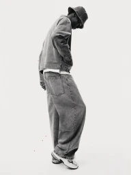Model Limamu Mbaye in full denim outfit with bucket hat against a plain white background for H&M