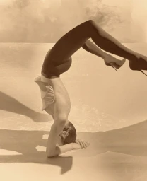 Model performing a headstand in dark tights and heels against a pale backdrop for Acne Paper