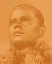 Close-up portrait of a model with slicked-back hair and a furry collar, rendered in a warm monochromatic orange tone.