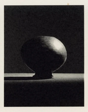 Monochromatic still life studio shot of round vase with foot, casting shadow against dark backdrop, showcasing texture and form.
