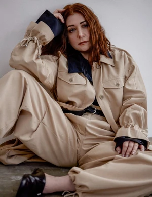 Alyson Hannigan seated wearing a beige jacket and matching trousers against a neutral background for Numero Netherlands.