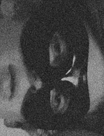 Monochrome, low-resolution image of a person wearing a graphic t-shirt; possibly in motion, creates a sense of motion and anonymity.