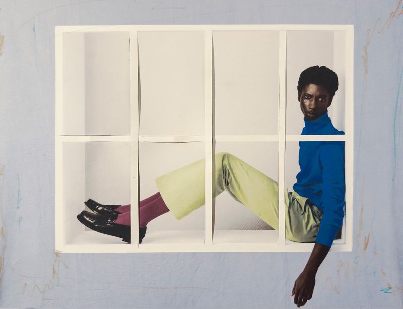 Fashion shot of a Black model in a blue turtleneck, light green pants, and black shoes posing inside a white frame against a blue background.