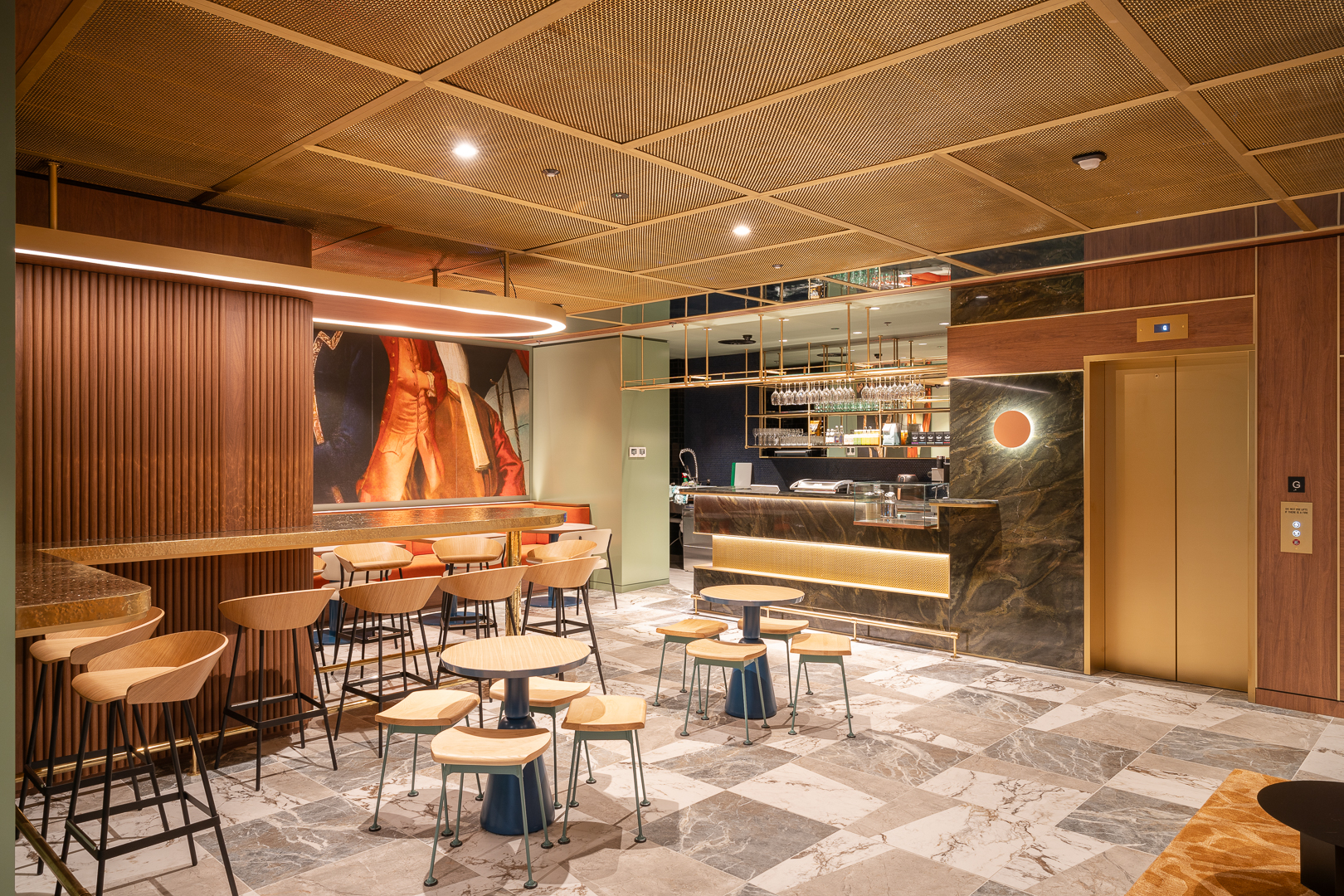 Interior of a restaurant with bar, tables, stools, marble floors, wooden panels, textured ceiling, and a golden elevator.