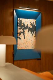 A detailed map artwork housed in a bright blue recessed frame on a dark wood paneled wall inside an office interior by Intermain.