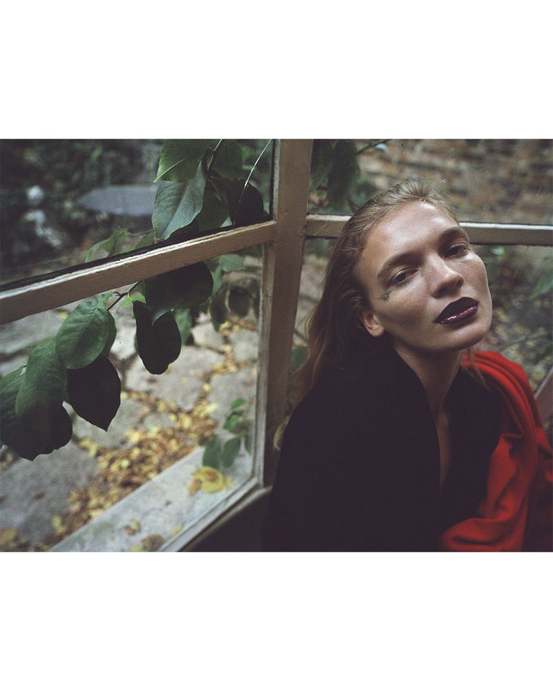 Model Caitlin Soetendal with dark lipstick near a window with foliage for D Repubblica editorial In my dreams