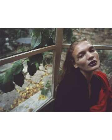 Model Caitlin Soetendal with dark lipstick near a window with foliage for D Repubblica editorial In my dreams
