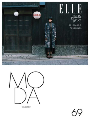 Model standing in front of dark wooden walls in Kyoto wearing a patterned coat, captured for Elle Mexico.