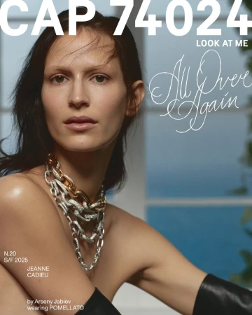 Magazine cover featuring a woman wearing a chain necklace, set against a backdrop of a window and sky, fashion advertisement.