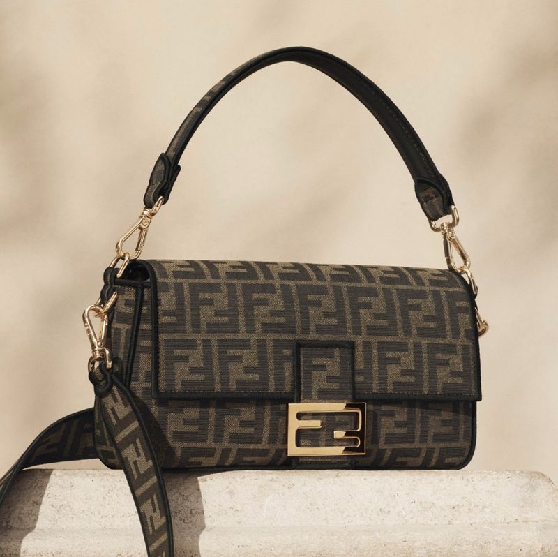 Stylish Fendi handbag with black straps and gold hardware, featuring a unique geometric Fendi logo pattern on a neutral background.