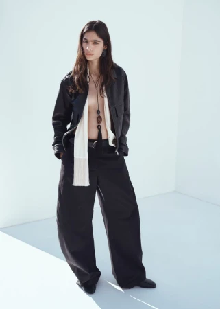 Model Loli Bahia wearing a black leather jacket and trousers against a white seamless background