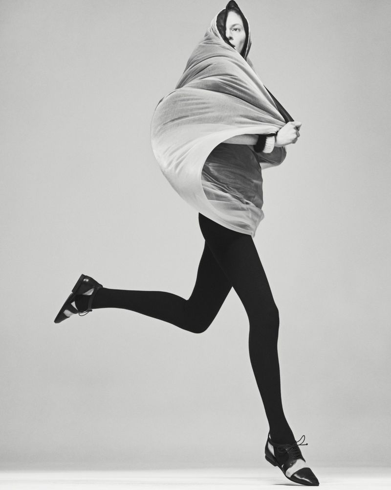 Model Julia Nobis wrapped in draped fabric running against a seamless grey studio backdrop for Mastermind Magazine