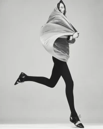 Model Julia Nobis wrapped in draped fabric running against a seamless grey studio backdrop for Mastermind Magazine
