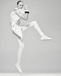 Model Julia Nobis jumping in white clothing against a seamless grey background for Mastermind Magazine.